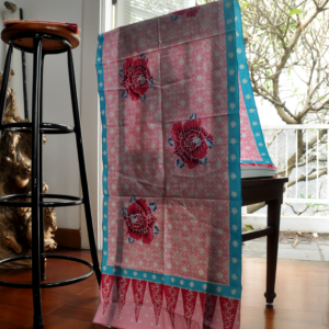 kain batik dengan aksen bunga mawar berwarna merah, diatas batik dengan kombinasi warna pink dan biru yang menjadikan selendang terlihat manis